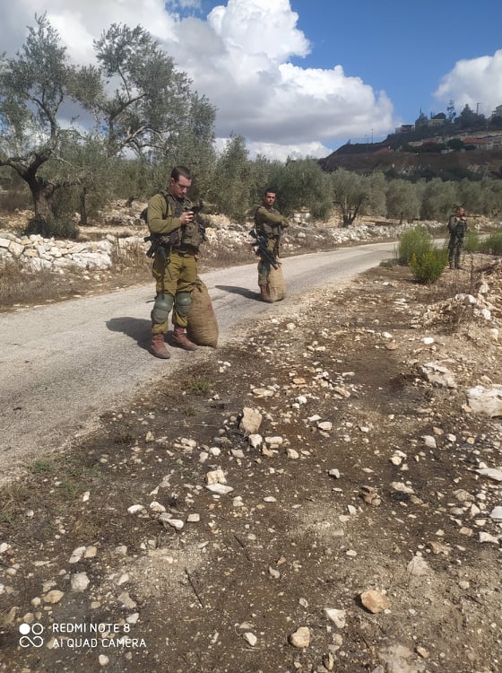 Soldiers with the olive sacks they took from the farmers. Photo courtesy of the Shteiwi family 