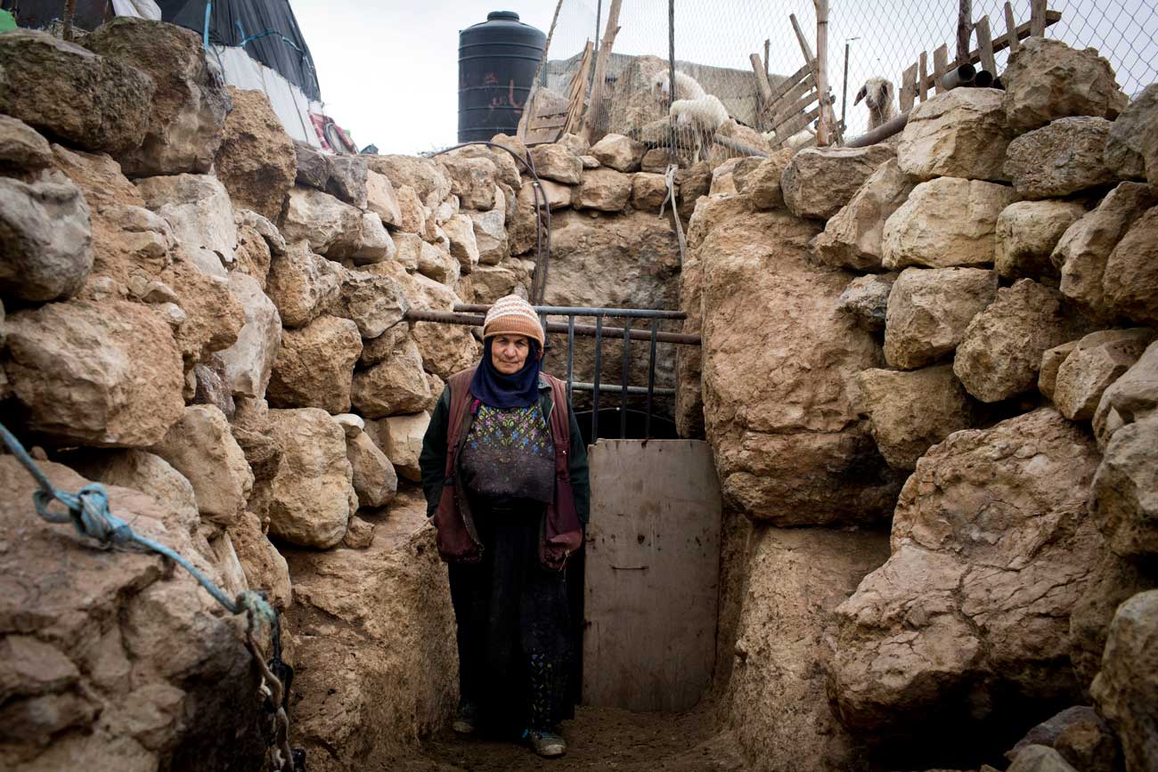 Fatmeh Abu Sabha at the entrance to a cave used as a sheep-pen. Photo: Oren Ziv, Activestills.org, 30 Jan. 2013.