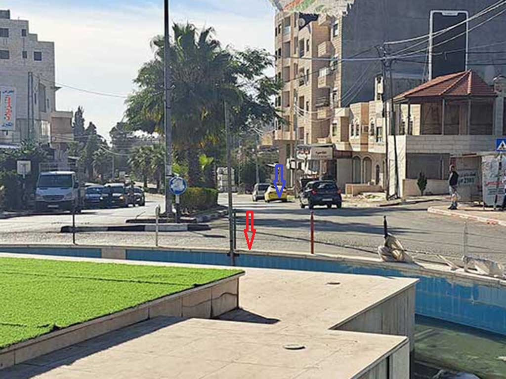 The "fruit roundabout" in Bitunya. The purple arrow marks where the border police officer fired from. The red arrow marks where Badran was shot. Photo: Iyad Hadad, B'Tselem, 3 Dec. 2023