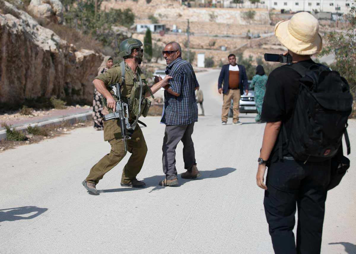 החייל המוכר לתושבים כמתנחל אוחז בכוח בבעל המטע. צילום: אבישי מוהר, אקטיבסטילס, 16.10.24