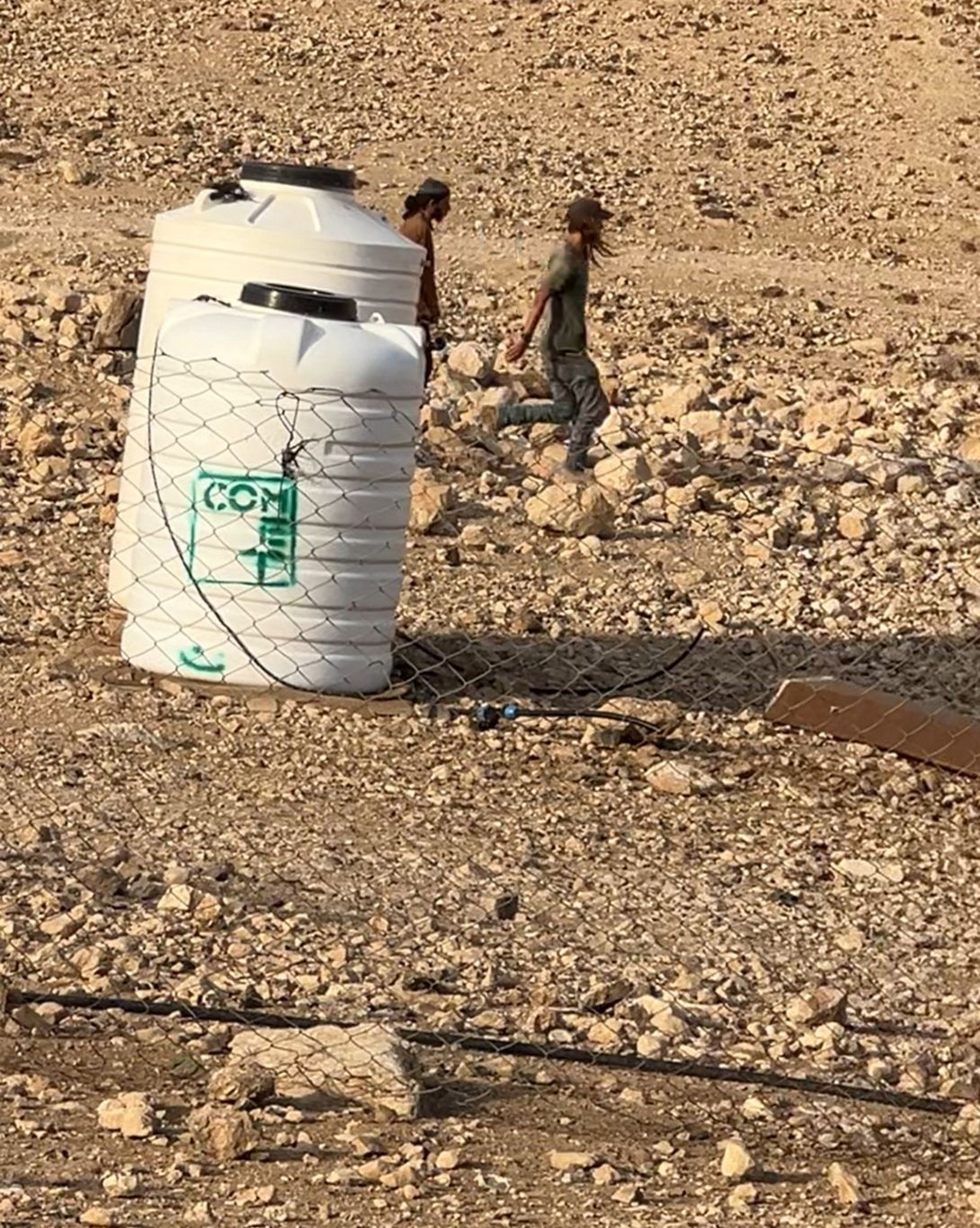 מתנחלים ליד בית המשפחות בראס עין אל-עוג'ה. התמונה באדיבות תושבים