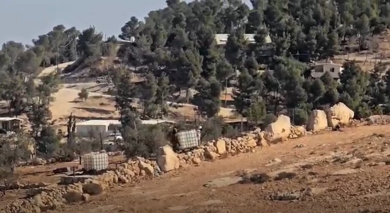 The settlers trying to steal the a water tanks from al-‘Adrah’s land. Photo courtesy of local residents