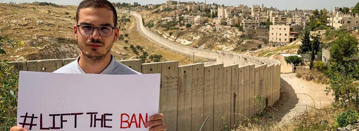 Laith Abu Zeyad against the background of the Separation Wall. Photo courtesy of Amnesty International