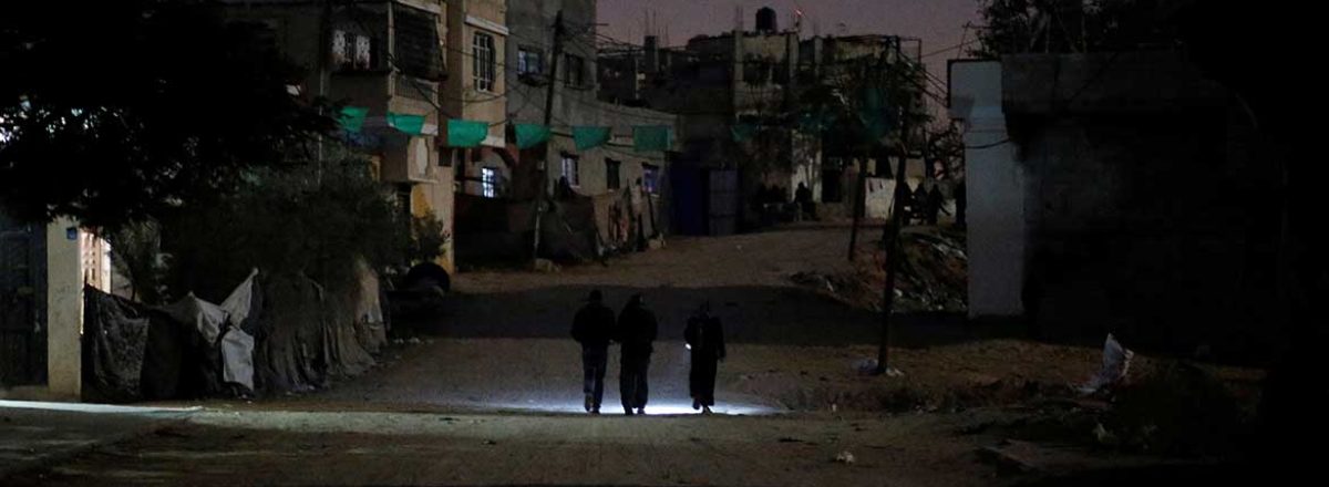 נשים הולכות ברחוב ברצועת עזה ללא תאורה, עקב הפסקת חשמל. צילום: מוחמד סאלם, רויטרס, 11 בינואר 2017.