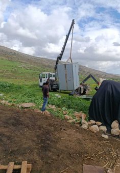 An outhouse being loaded onto a vehicle ahead of departure. Photo courtesy of the residents
