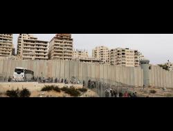 Palestinian children from Shu'fat refugee camp walk towards an Israeli checkpoint on their way to schools in other parts of East Jerusalem