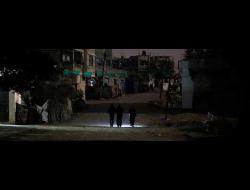 Palestinian women walk along unlit street in Gaza during power blackout. Photo by Mohammed Salem, Reuters, 11 Jan. 2017