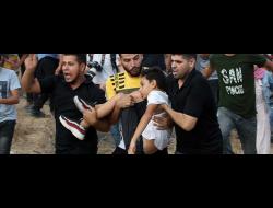 شبان يحملون المصاب عمر أبو النيل وينقلونه لتلقي العلاج بعدما أطلق الجنود الرصاص عليه وأصابوه في رقبته. تصوير: عبد الرحيم الخطيب