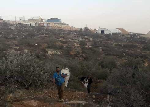 مزارع من قريوت وفي الخلفية البؤرة الاستيطانية "هيوفيل" في كانون الثاني 2020. تصوير أحد سكان القرية