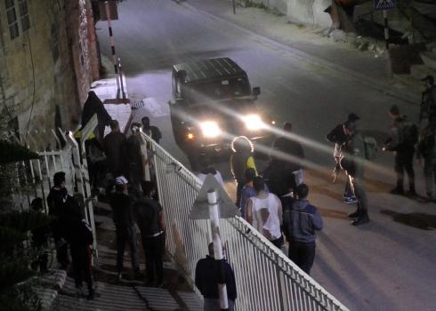 سكّان حارة غيث وراء البوابة المنصوبة في الجدار بعد أن أغلقها الجيش ، الخليل