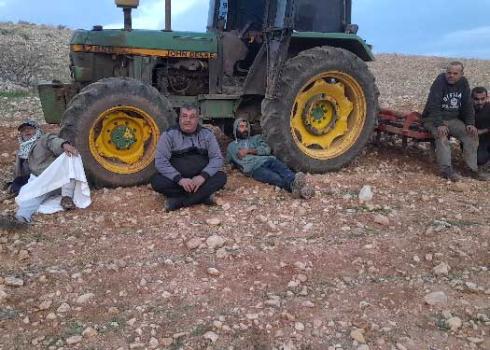 החקלאים המעוכבים ליד הטרקטור. התמונה באדיבות החקלאים