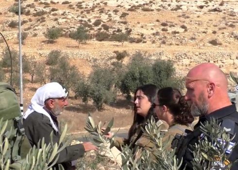 אנשי הכוח אוסרים על אחד החקלאים למסוק באדמתו. התמונה באדיבות הפעילים