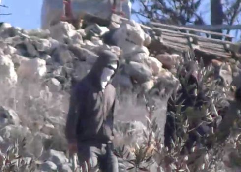 מתנחל רעול פנים וחמוש באלה במהלך האירוע. צילום: אבישי מוהר, בצלם 