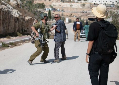 החייל המוכר לתושבים כמתנחל אוחז בכוח בבעל המטע. צילום: אבישי מוהר, אקטיבסטילס, 16.10.24