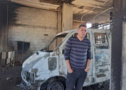 מוחמד שחאדה ליד משאיתו ששרפו המתנחלים. צילום: סלמא א-דיבעי, בצלם, 4.12.24