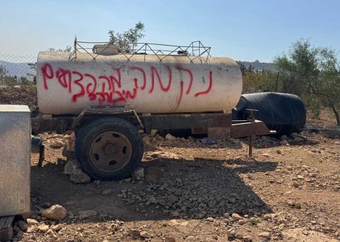 הכתובת שריססו המתנחלים על מכלית המים. צילום: מוחמד רומאנה, בצלם