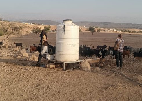 מתנחלים עם צאן ליד מכל מים של תושבי הקהילה. התמונה באדיבות התושבים, 26.10.25