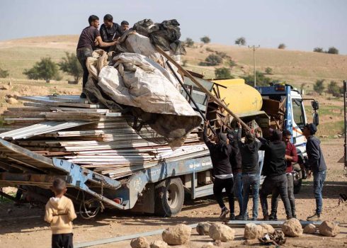 תושבי ראס עין אל-עוג'א מעמיסים יריעות אוהלים על משאית לקראת עזיבה. צילום: קרן מנור, בצלם