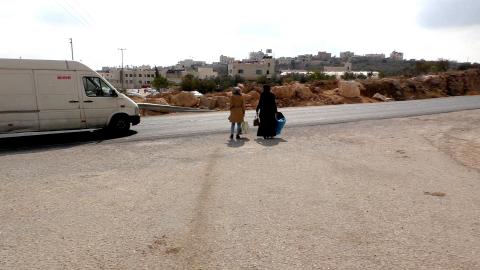 نساء يعبرن شارع رقم 60 بالقرب من مدخل خربة قلقس. الصورة من التوثيق بالفيديو.