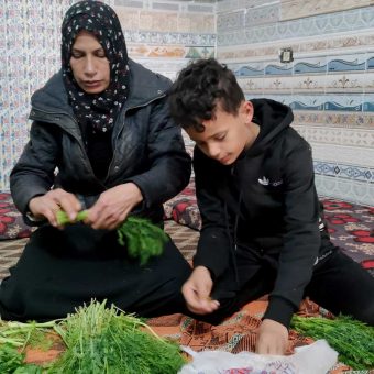 'Ula Karim and one of her children prepare vegtables for the stnad