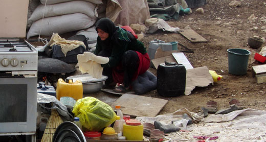 Living in ruins: A resident of Khirbet 'Ein Karzaliyah  bakes bread. Photo: ‘Atef Abu a-Rub, B'Tselem, 13 January 2014