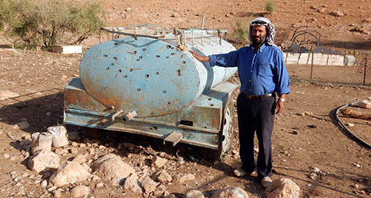 Muhammad Myadmeh by his water tank in al-Fajam after it was used by soldiers for target practice. Photo by ‘Aref Daraghmeh, B’Tselem, 17 Oct. 2016